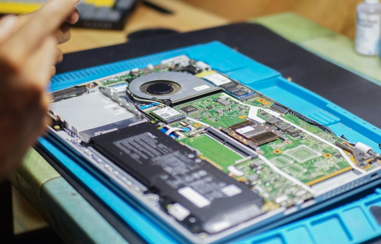 pexels photo 34514242 34514242 Close-up of laptop being repaired with visible components and tools.