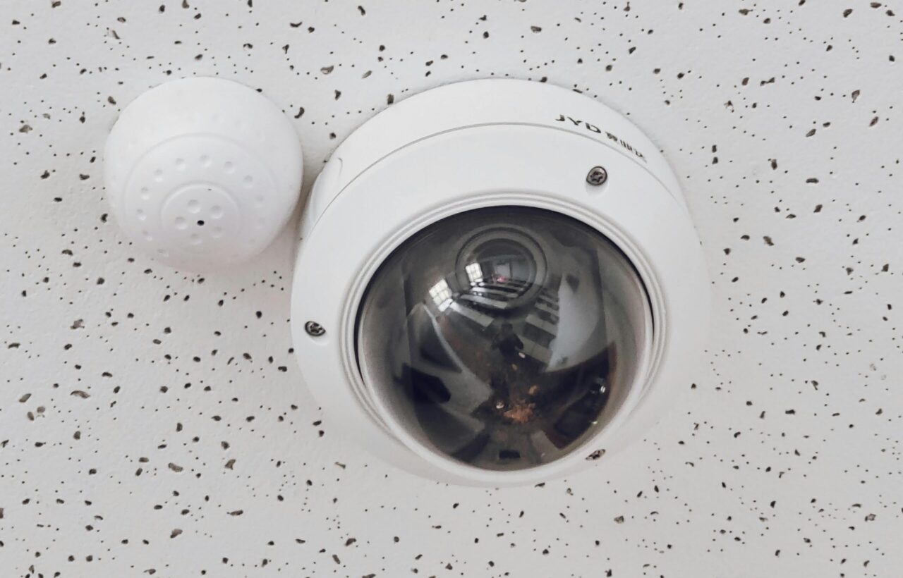 pexels photo 7508684 7508684 Close-up of a round dome surveillance camera installed on a speckled ceiling for security monitoring.